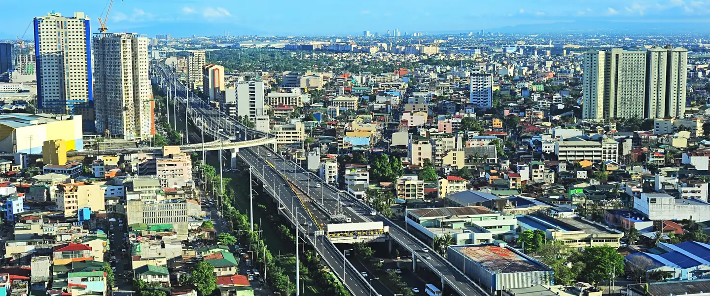 A panoramic view of the diverse Manila City skyline, showcasing high-rise developments, commercial properties, and thriving urban districts.