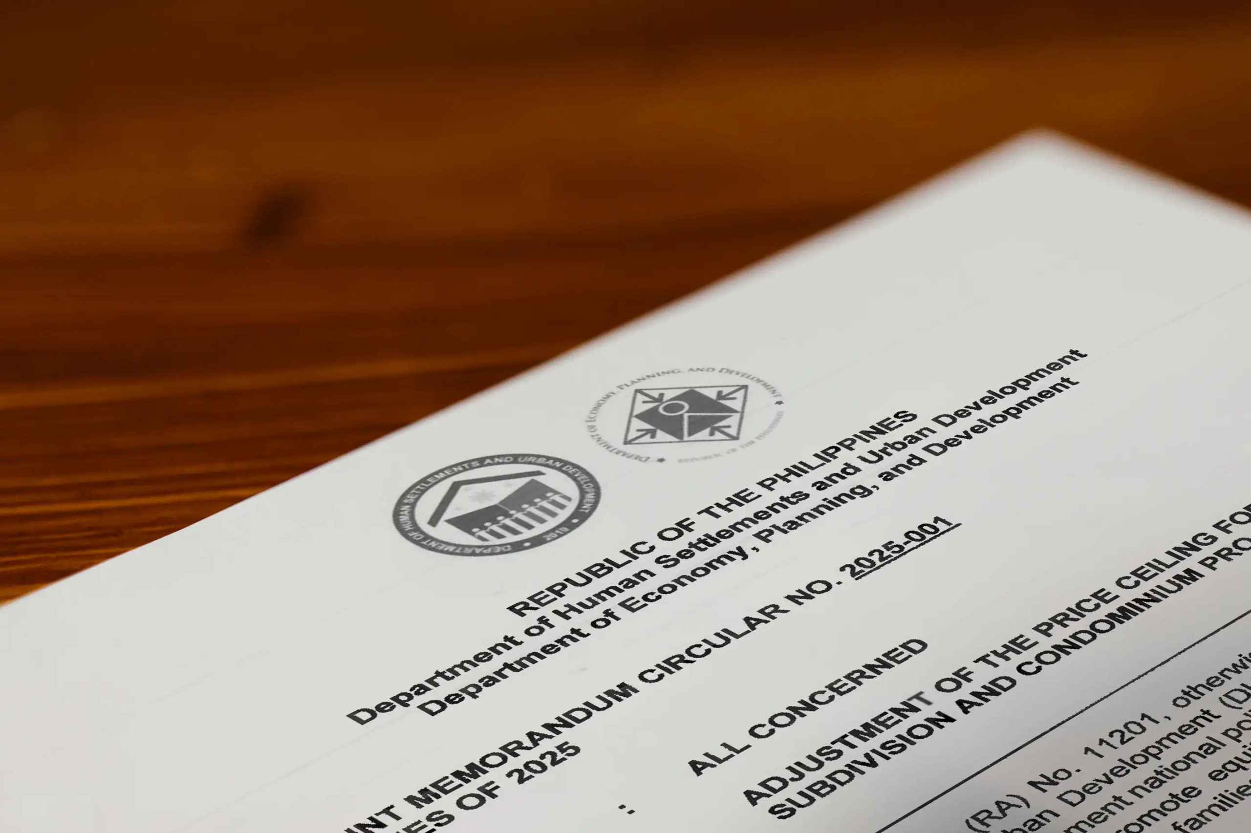 A close-up photograph of the official DHSUD memorandum order document outlining the updated socialized housing price ceilings in the Philippines.