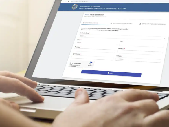 A person using a laptop to check the Professional Regulation Commission (PRC) online verification system to confirm a real estate broker's license status.