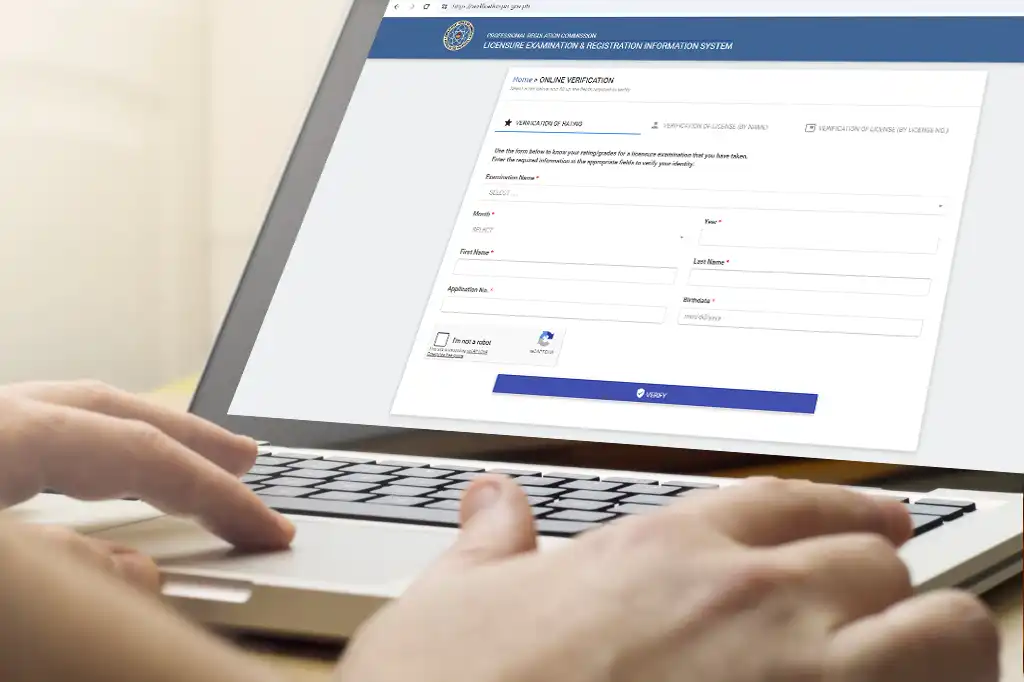 A person using a laptop to check the Professional Regulation Commission (PRC) online verification system to confirm a real estate broker's license status.